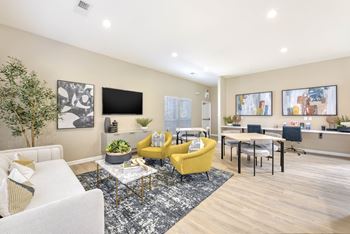 A living room with a yellow chair and a white couch.